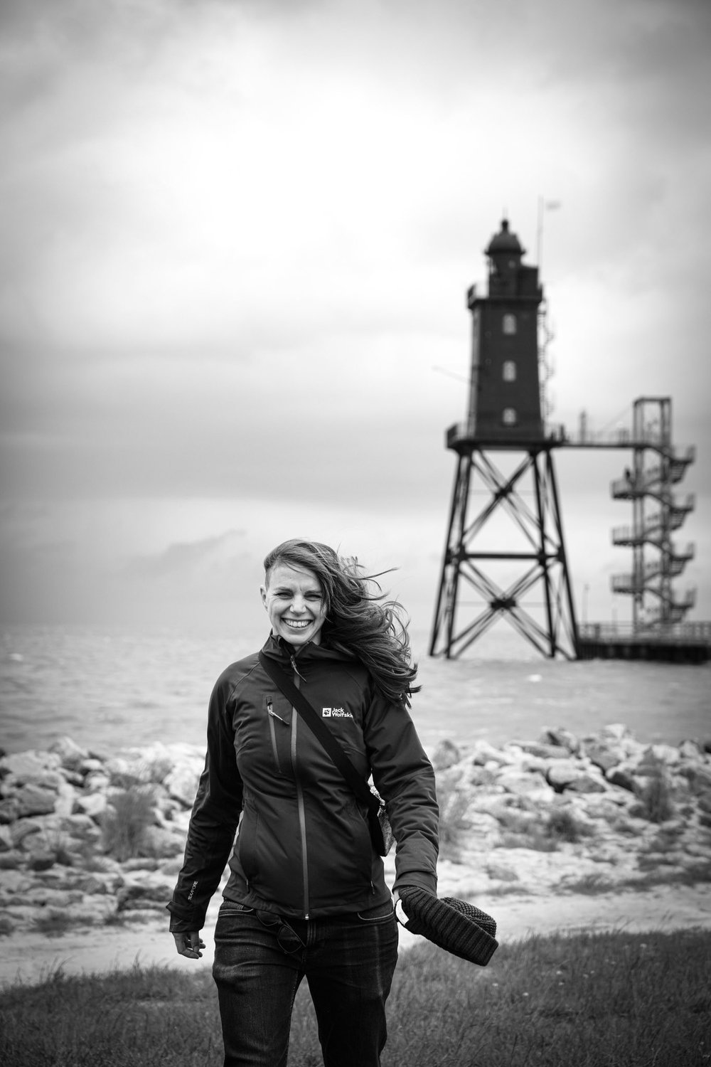 Julia Schnetzer lachend am Leuchtturm im Wind